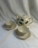 Group view of teapot with two cup and saucer sets