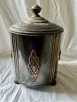 Full view of coal bucket showing lid, feet and decorative panel