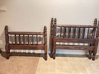 Two antique solid wood spindle bed ends, one taller (headboard) one shorter (footboard)