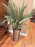 Full view of artificial fern in metal planter