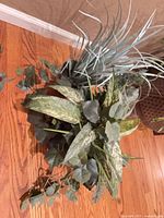 Mixed foliage arrangement with spotted leaves, grass-like spikes, eucalyptus