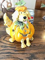 Front view of ceramic dog pumpkin luminary next to 12-oz can for scale