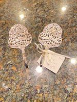 front view of two silver-tone pastry servers on countertop