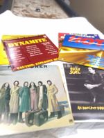 Group shot of six vinyl record albums, four titles clearly visible