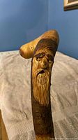 Close-up of carved bearded face on cane handle