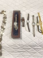 Group view of six watches and chain laid out on surface