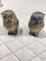 Front view of two metal owl incense burners