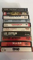 Stacked view of cassette spines showing album titles and bands