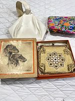 Overview of all three bags: beaded purse in box, white handbag, floral pouch