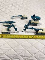 All five Resas CT-300 toy excavators grouped with measuring tape for scale
