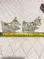 two clear glass terrier containers beside tape measure