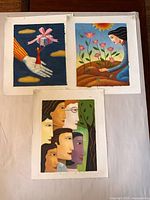 Overview of three unframed oil paintings on paper