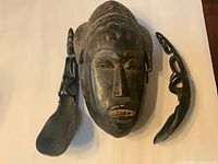 Baule mask centered with two horn ladles beside