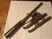 Overall view of brass telescope and wooden skates