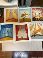 All six unframed circus-themed oil paintings laid out