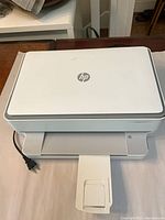 Top view of HP Envy 6055e printer with power cord and output tray
