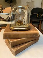 Front view of Kern anniversary clock atop three dictionary volumes