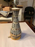 Full view of conical ceramic lamp on brass-toned base