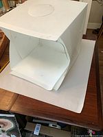 Overall view of folded white tabletop photo lightbox on table