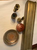All metal items grouped: bowl, jar lid removed, four brass vases, jardiniere