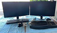 Two Acer monitors, two keyboards, wired mouse visible