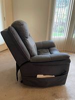 Right side view of recliner in upright position showing upholstery and storage pocket