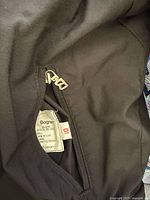 Bogner size tag and interior pocket of black ski bibs