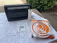 FoodSaver V3440 unit front view with roll, manual, Airtight Plus lids pack