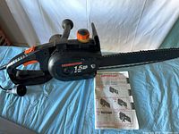 Full view of chain saw with booklet