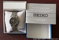 Watch in open Seiko box with instruction booklet visible