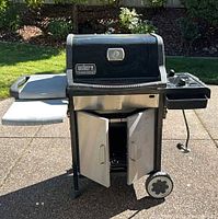 Front view of Weber Genesis Silver A grill with doors open showing lower cabinet