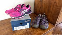 ASICS pink shoes on box beside Keen purple sandals