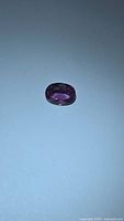 Loose oval pink-purple sapphire on neutral background