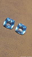 Two cushion cut aquamarines on surface