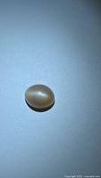 Top view of oval peach moonstone cabochon showing color and surface