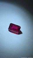 Emerald-cut blood red ruby front view under spotlight