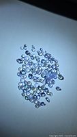 Loose round brilliant-cut tanzanites spread on white background