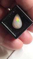 Front view of pear cabochon white opal showing play-of-color
