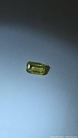 Emerald-cut yellow sapphire under angled light