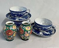 Group shot of three teacups on saucers and three miniature vases
