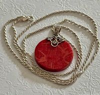 Full necklace coiled showing chain texture and pendant front