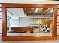 Front view of entire mirror showing teak veneer frame and reflective surface