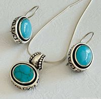 Front view of turquoise earrings and pendant necklace showing design, stone colour and Greek key border