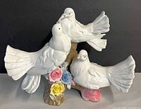 Front view three white doves on floral tree base