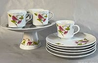 full set showing cake stand with cups and stacked snack plates
