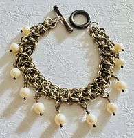 Full view of bracelet front side showing chain weave and pearl drops