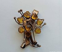 Front view of gold-tone brooch with amber stones