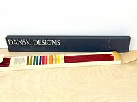 Closed Dansk Designs box beside open tray showing red tapers