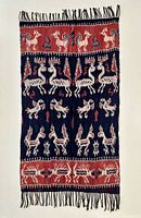 Full view of the hand-woven ikat textile hanging to show complete pattern and fringe