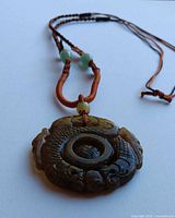 full view of necklace showing pendant and braided silk cord